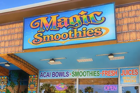 The Magic Smoothies storefront by day: the sign over the shop windows, the tiki columns and the steps