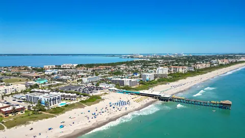 Cocoa Beach from the air on a clear day: the sand, the surf and the pier, with the town behind